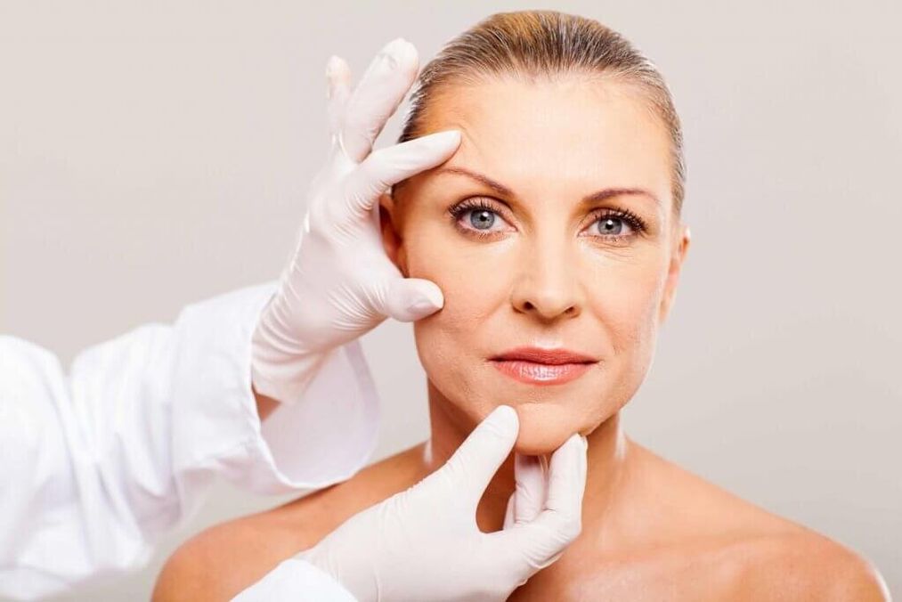 the doctor examines the skin before rejuvenation